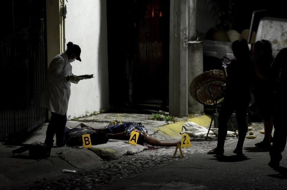  forensic medic investigates the crime scene where two people were shot dead by unidentified attackers in Acapulco, Mexico, Thursday, Dec. 8, 2016.  (AP Photo/Bernandino Hernandez)