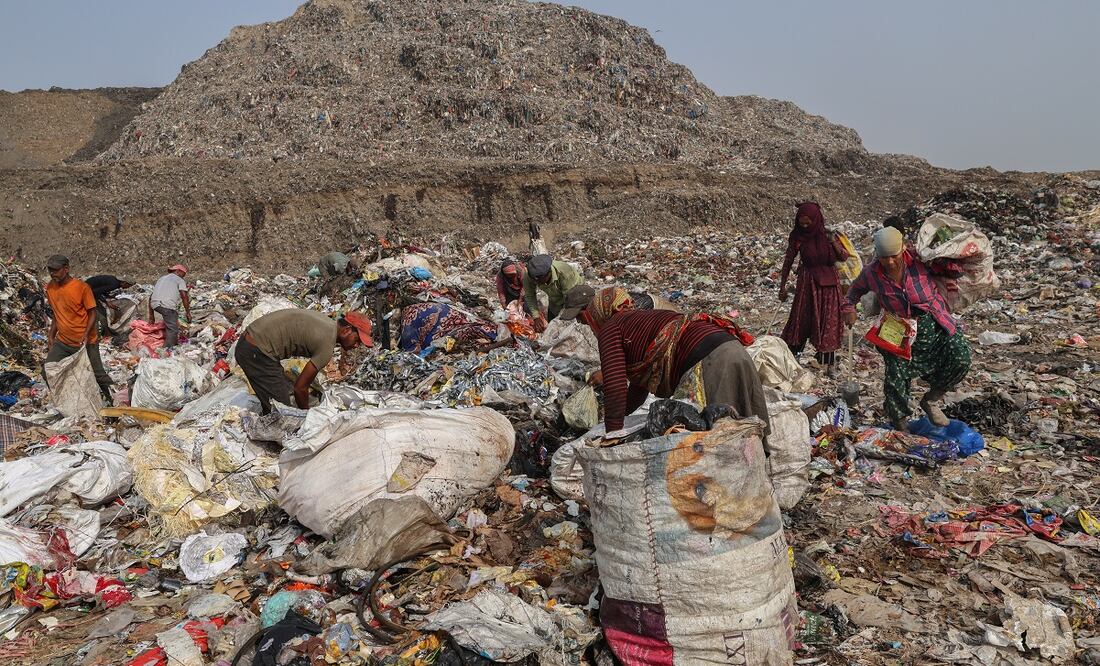 Recolectores de residuos buscan artículos reutilizables entre los residuos vertidos en un vertedero en Nueva Delhi, India. Foto: EFE
