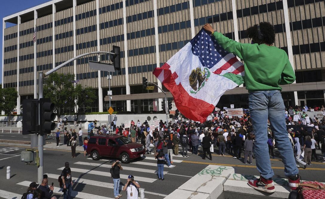 Una persona sostiene una bandera mexicana-estadounidense el viernes 6 de junio de 2025, después de autoridades federales de inmigración llevaran a cabo un operativo migratorio. Foto: AP