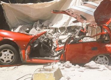 Camión de carga vuelca y cae sobre auto compacto en Tecámac