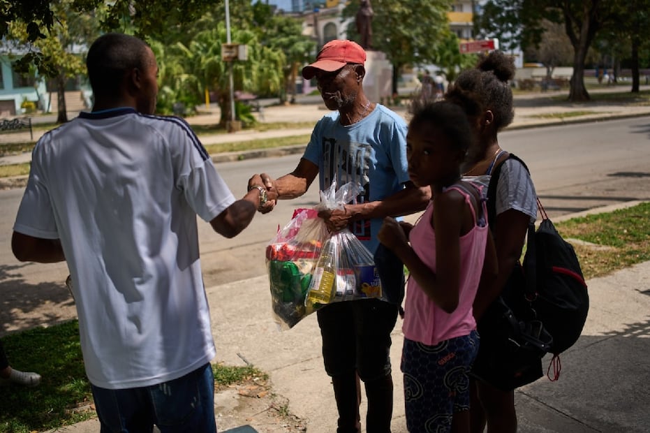 Un vecino recibe un paquete con productos básicos. Foto: AP.