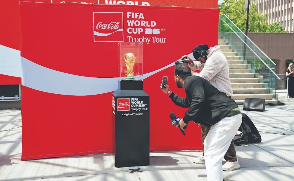 Personas graban videos del trofeo de la Copa Mundial de la FIFA, durante un evento de la Gira del Trofeo en la plaza Nathan Phillips de Toronto. Foto: AFP