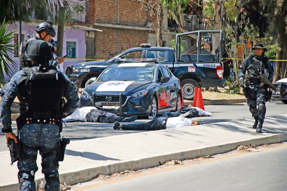 Los policías intentaron protegerse detrás de una patrulla, pero fueron abat i do s por los hombres armados, en la colonia La Gloria. (CUARTOSCURO)