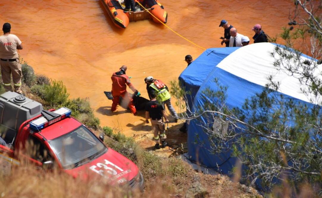 Policías revisan una maleta tras extraerla del Lago Rojo, cerca de Mitsero, en Chipre (Foto: EFE)