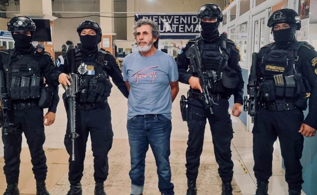 Fotografía cedida por el Ministerio de Gobernación de Guatemala donde se ve al narcotraficante, Baldomero Samayoa, alias Chicharra (c) custodiado por miembros de la Policía Antinarcóticos de Guatemala este miércoles, en Ciudad de Guatemala (Guatemala). Samayoa es parte de la lista de los 100 más buscados por Estados Unidos y tiene una orden de extradición pendiente por lavado de dinero, así como trasiego de cocaína, heroína y otros ilícitos. Foto: EFE