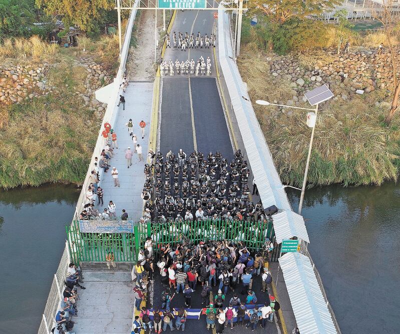 Contención. Migrantes esperaban ayer a que las autoridades abrieran la frontera entre Guatemala y México. Foto: EFE