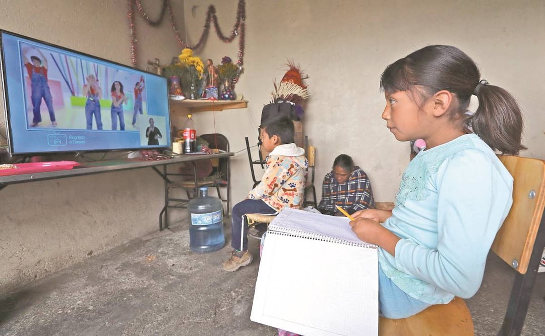 Jimena, quien ingresó a primero de primaria, toma su clases frente al televisor, mientras el resto de sus hermanos observan cómo estudia. A estas dificultades se enfrentan los pobladores de la región otomí de Toluca. Foto: JORGEA LVARADO. EL UNIVERSAL