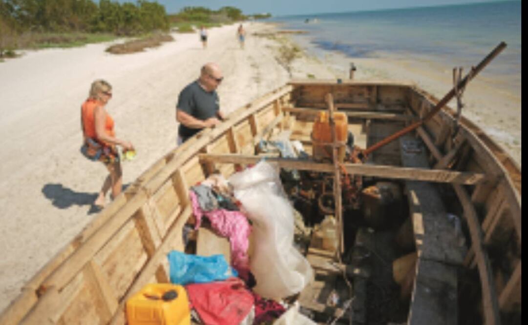 Tom y Andrea Heinz revisan una barca en la que aparentemente migrantes llegaron a Coco Plum Beach, en Florida, una zona donde suelen arribar cubanos y haitianos. 