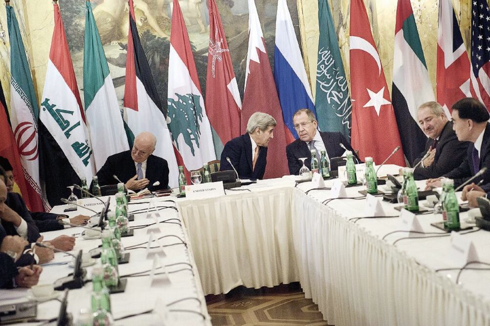 El secretario de Estado de EU, John Kerry (centro, izquierda) conversa con el canciller ruso, Serguei Lavrov, antes del inicio, este viernes, de la cumbre en Viena sobre la crisis siria. (BRENDAN SMIALOWSKI. REUTERS)