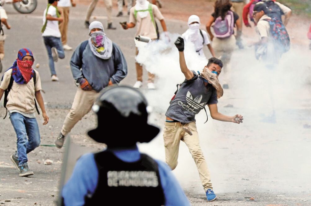 Agentes, durante una manifestación contra el presidente hondureño, Juan Orlando Hernández, en Tegucigalpa. FOTO/ORLANDO SIERRA. AFP