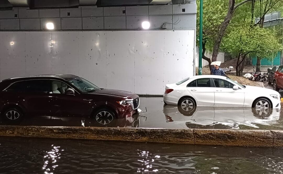 Una camioneta y un auto tipo sedan se quedaron varados en el bajo puente del camino Santa Teresa cuando el agua les llegó al motor. Foto: Especial