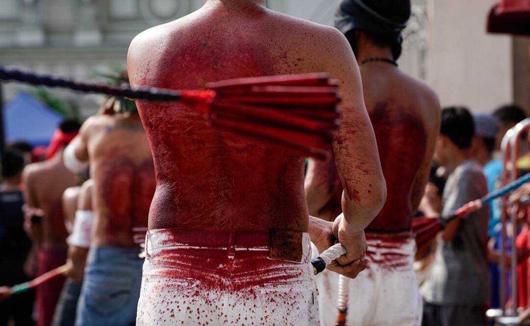 Penitentes se fustigan mientras caminan en procesión hacia una iglesia con el rostro cubierto durante las celebraciones de Semana Sanata en Filipinas. Foto: EFE.