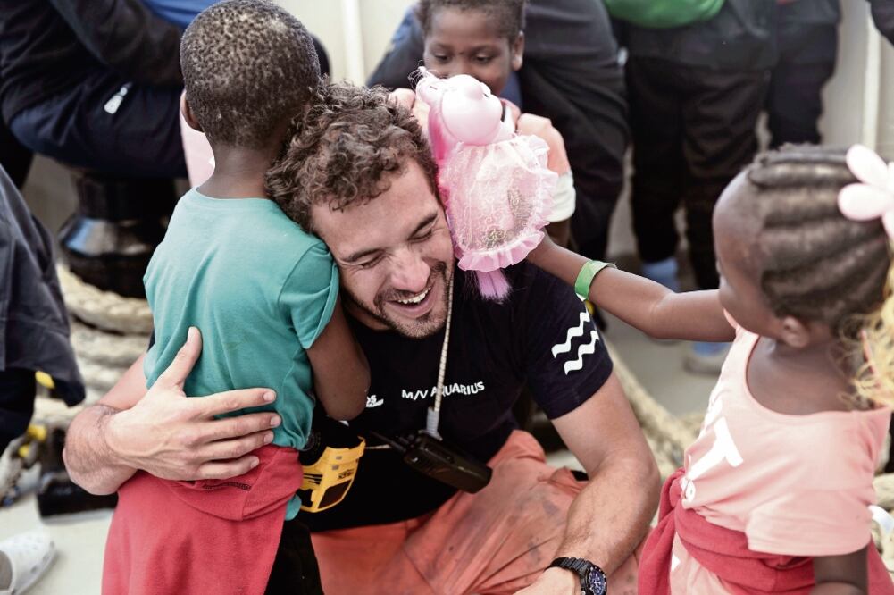 Un miembro de la tripulación abraza a un niño a bordo del barco Aquariu s antes de arribar a Valencia, España, país que decidió acoger a los inmigrantes después de que Italia y Malta se negaran a recibirlos en su territorio. Foto: REUTERS