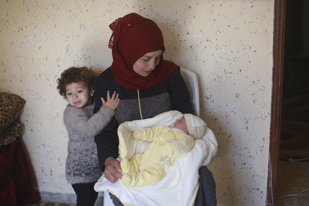 Samira Nimr posa junto a sus hijos Ibrahim (en brazos) y Yasmin (dcha) en su casa del campo de refugiados de Nour Shams (Foto: EFE)