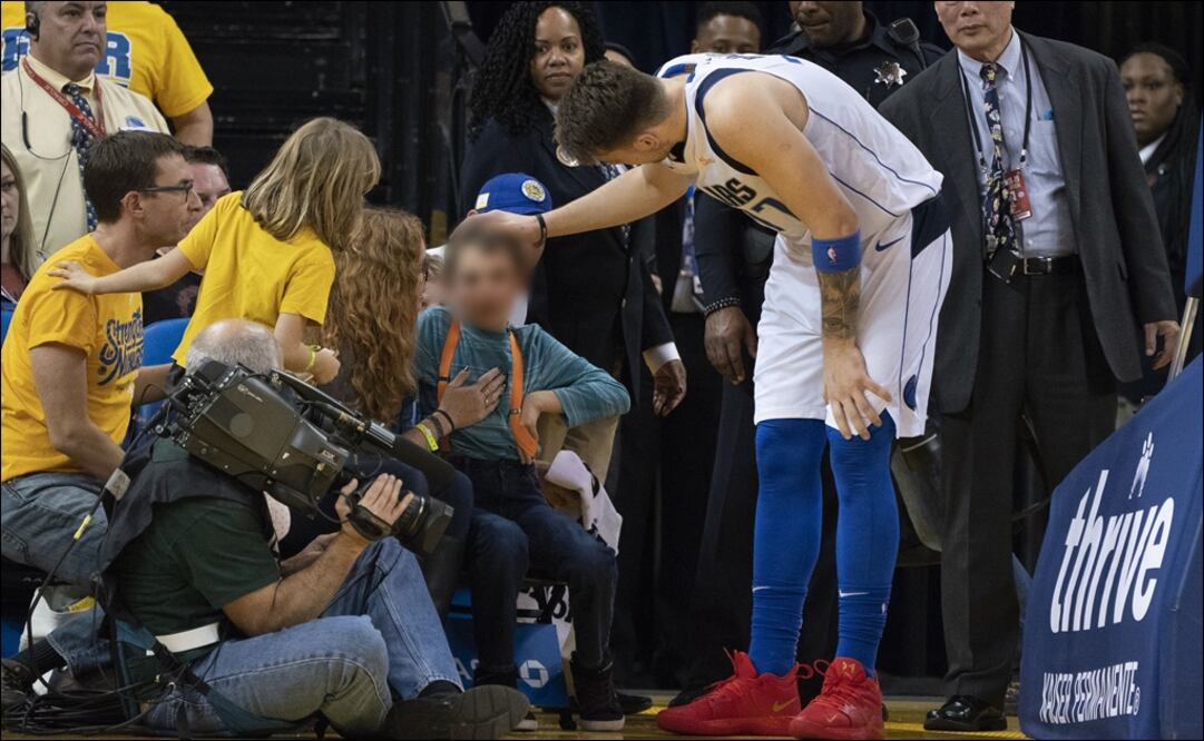 Luka Doncic revisa que el niño esté bien. Foto: Reuters