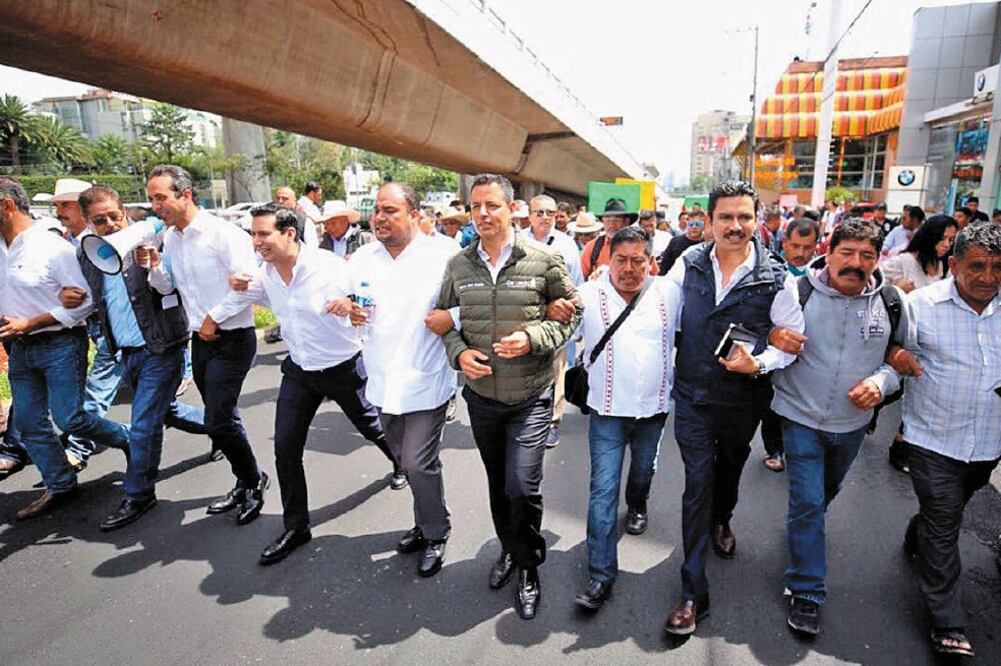 Encabezados por el gobernador Alejandro Murat (al centro, de chamarra), mezcaleros llegaron a la CDMX en 18 autobuses y caminaron hasta el IMPI (ESPECIAL)