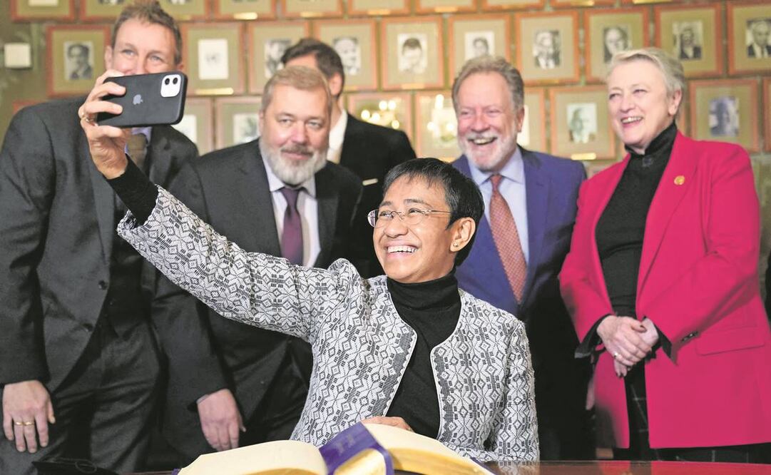 La periodista filipina Maria Ressa (centro) y su colega ruso Dmitri Muratov (segundo de izquierda a derecha), premiados con el Nobel de la Paz, ayer en Oslo con el comité noruego. Foto: AFP.