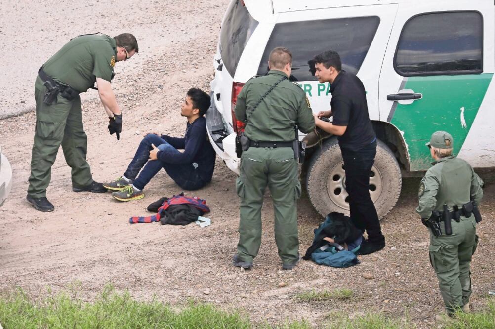Agentes de la Patrulla Fronteriza detienen a dos indocumentados tras capturarlos cerca de McAllen, Texas. Activistas y grupos como la central sindical AFL-CIO reclaman una reforma migratoria en EU con vía a la legalización (AFP)