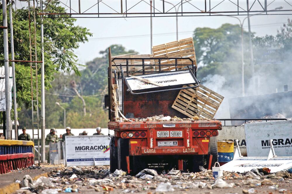 Un camión con ayuda humanitaria incendiado el sábado en el Puente Francisco Santander, que conecta Colombia con Venezuela, permanecía ayer en la zona. EDGARD GARRIDO. REUTERS