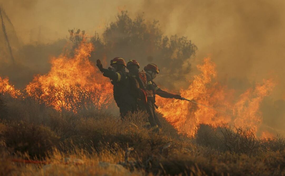Bomberos usan una manguera para extinguir un incendio cerca de la localidad de Ierapetra, en la costa sur de la isla de Creta, Grecia, el 3 de julio de 2025, durante un incendio de rápido avance que llevó a las autoridades a desalojar pueblos y zonas costeras. Foto: AP
