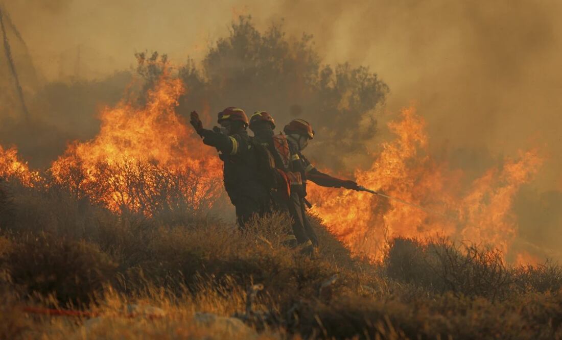 Bomberos usan una manguera para extinguir un incendio cerca de la localidad de Ierapetra, en la costa sur de la isla de Creta, Grecia, el 3 de julio de 2025, durante un incendio de rápido avance que llevó a las autoridades a desalojar pueblos y zonas costeras. Foto: AP