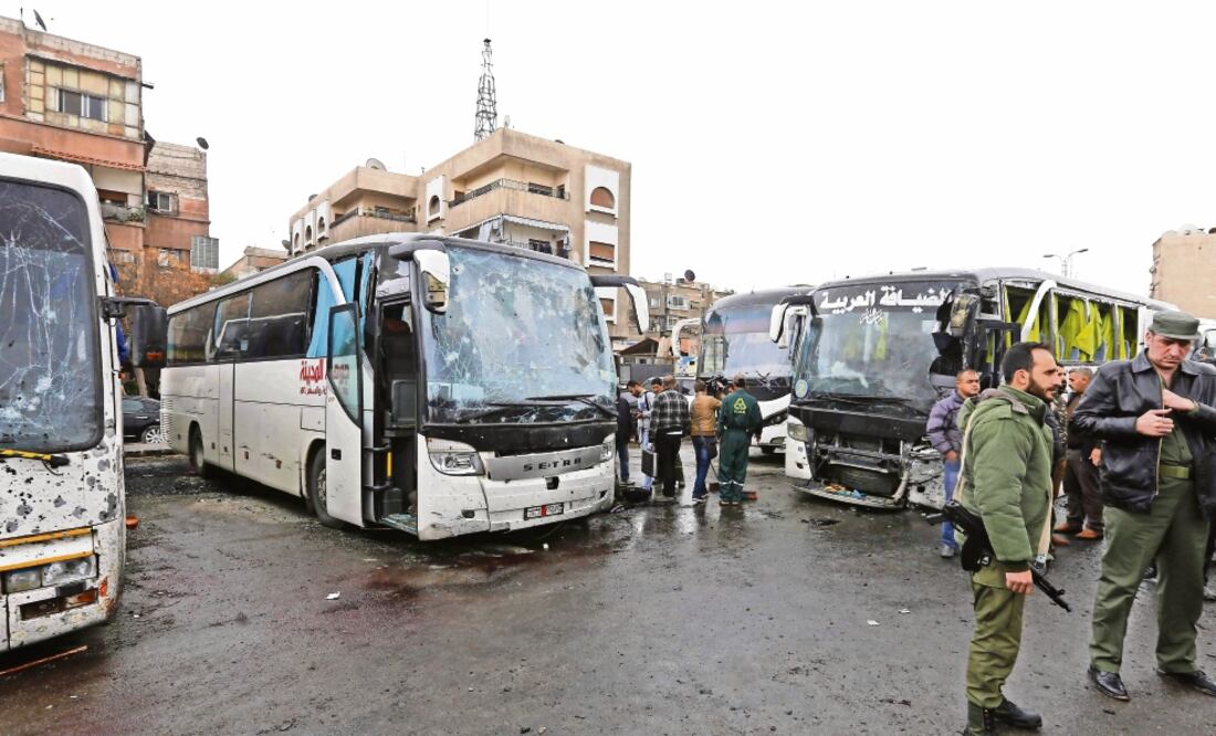 Fuerzas sirias de seguridad y lugareños se reunieron ayer en el lugar donde se produjo el doble atentado, en Damasco. En la zona hay varios mausoleos chiítas. (LOUAI BESHARA. AFP)