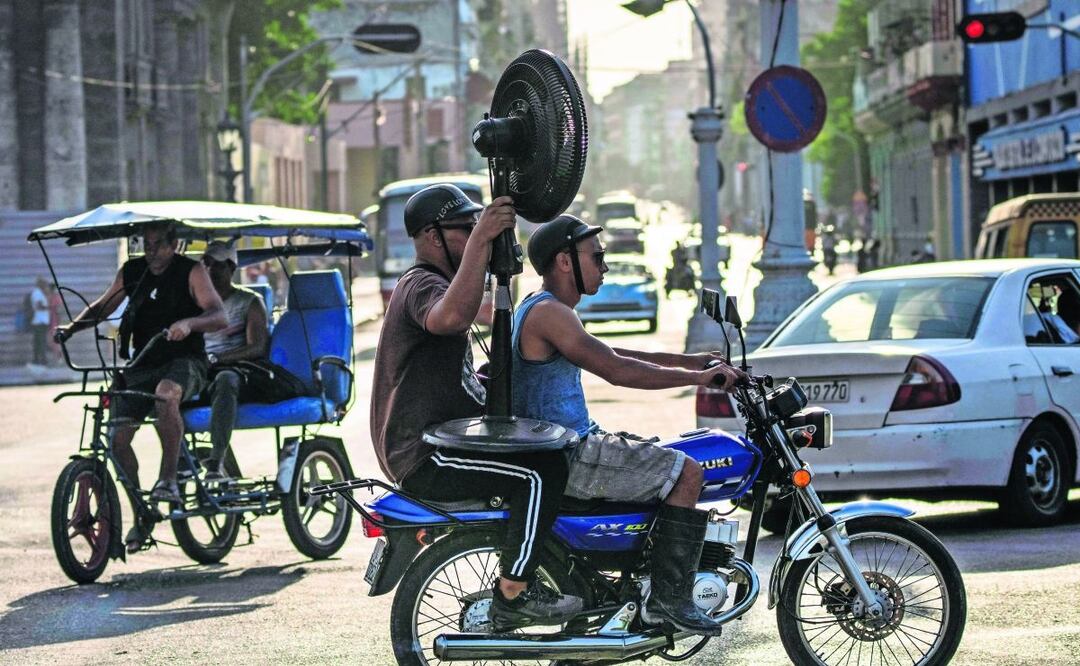 Cubanos, en motocicleta con un ventilador en La Habana. A los habitantes de la isla no les sorprendió la reelección de Díaz-Canel, Foto: Ramón Espinosa. AP