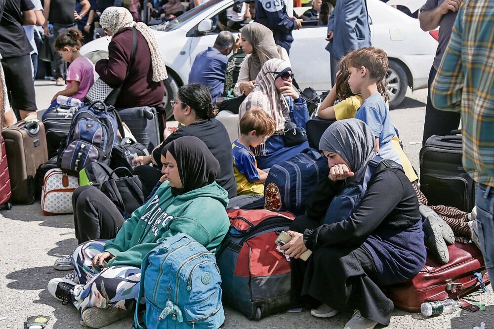 Palestinos con doble nacionalidad esperan para cruzar por el paso fronterizo de Rafah con Egipto, en el sur de la Franja de Gaza. Foto: EFE