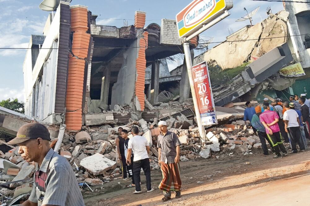 Habitantes de Ule Glee observan uno de los edificios destruidos por el terremoto que golpeó esta madrugada la provincia de Aceh, en la isla de Sumatra, Indonesia (NUNU HUSIEN. REUTERS)