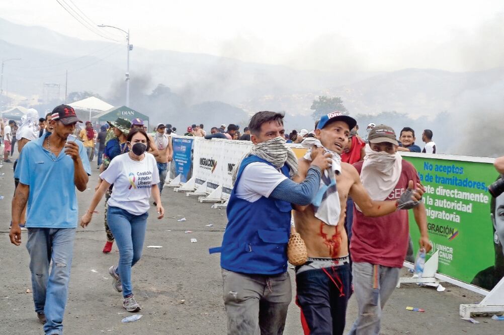 Voluntarios ayudan a una persona que resultó herida durante los choques con las fuerzas de seguridad leales a Maduro, en el Puente Internacional Simón Bolívar. Foto: JOSÉ MELÉNDEZ. EL UNIVERSAL