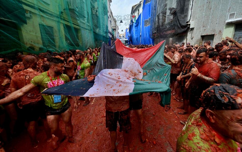Asistentes a la Tomatina ondean una bandera palestina durante la popular fiesta de Buñol, al este de España, el 27 de agosto de 2025. Foto: AFP