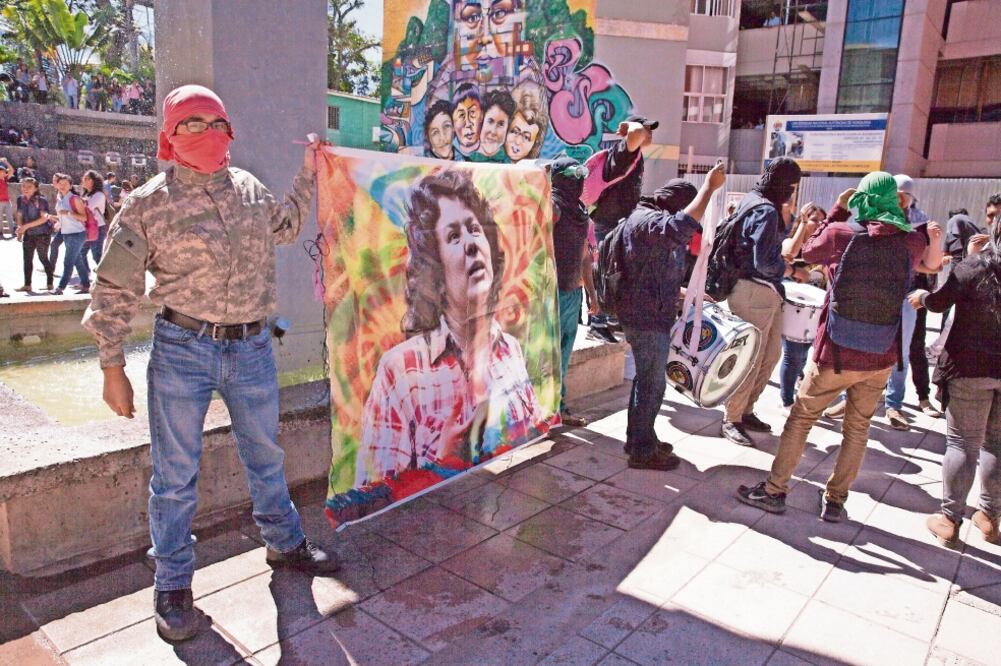 Estudiantes de la Universidad Nacional Autónoma de Honduras sostienen una imagen de Berta Cáceres, durante una manifestación ayer en Tegucigalpa, al cumplirse un año del asesinato de la líder ambientalista (GUSTAVO AMADOR. EFE)