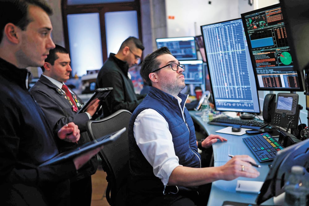 Operadores trabajan en la Bolsa de Valores de Nueva York; las acciones en Wall Street se dispararon ayer. Foto:  AFP
