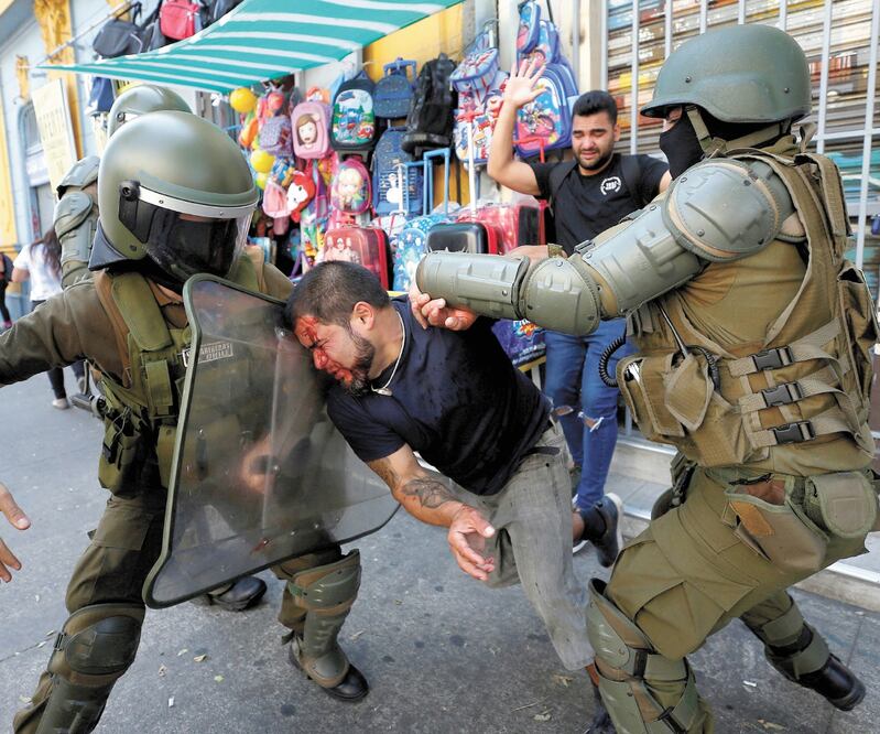 Un hombre al ser detenido por las fuerzas de seguridad, ayer durante las manifestaciones por el Día Internacional de la Mujer en Valparaíso. Foto: RODRIGO GARRIDO. REUTERS