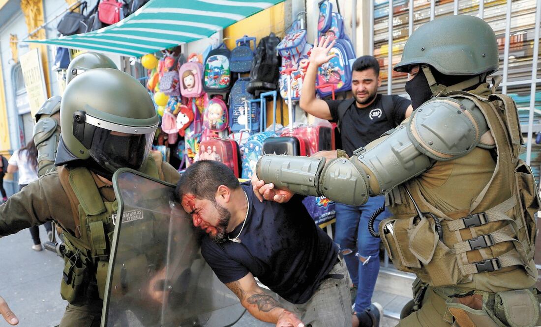 Un hombre al ser detenido por las fuerzas de seguridad, ayer durante las manifestaciones por el Día Internacional de la Mujer en Valparaíso. Foto: RODRIGO GARRIDO. REUTERS