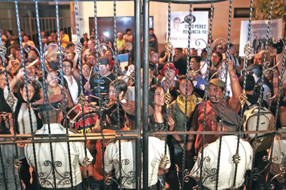 Ciudadanos exigen la renuncia del presidente Otto Pérez Molina, a la entrada de la Casa Presidencial de Guatemala (ESTEBAN BIBA. EFE)