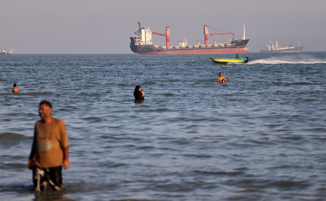 Habitantes nadan en las aguas del estrecho de Ormuz mientras buques mercantes permanecen en la zona, en medio de la tensión por el tránsito marítimo. Foto: AP