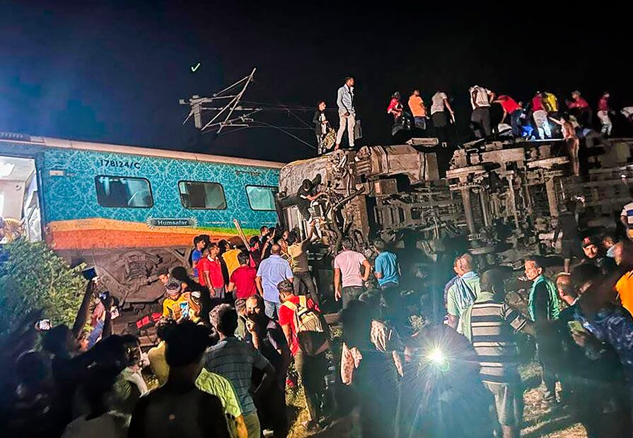 La gente inspecciona el sitio de los trenes de pasajeros que descarrilaron en el distrito de Balasore, en el estado de Orissa, en el este de India, el viernes 2 de junio de 2023. Foto: AP