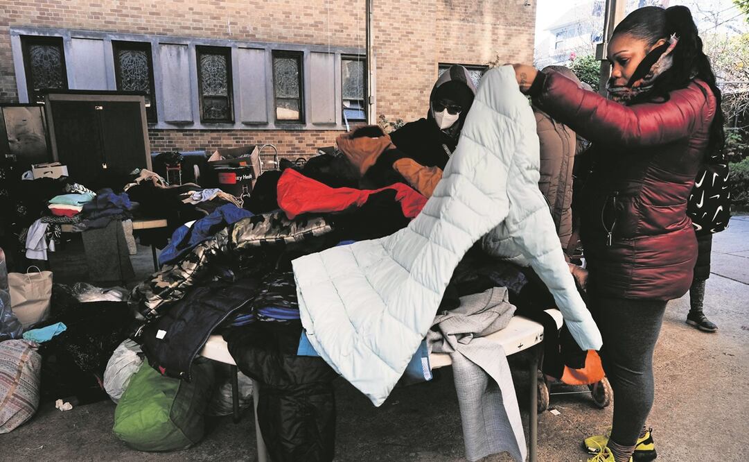 Estadouni-denses ven ropa, mientras hacen fila para recibir un pavo gratis por Acción de Gracias en Brooklyn, el 21 de noviembre pasado. Foto: Archivo / AFP
