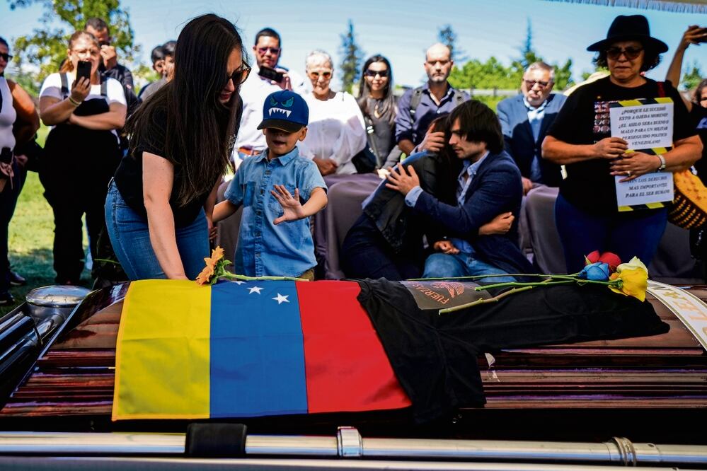 Familiares del exmilitar disidente venezolano Roland Ojeda, lo entierran en el Cementerio de Canaán en Santiago, Chile. El gobierno atribuye el asesinato al Tren de Aragua Foto: Esteban Felix / AP