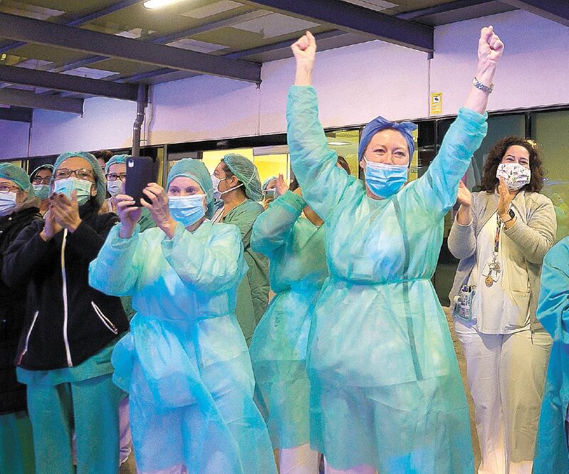 Trabajadores de la salud responden a las porras que les envían las personas en Valencia. España alcanzó 4 mil 365 fallecidos y casi 58 mil contagiados, de acuerdo con los últimos datos divulgados por la Universidad Johns Hopkins.JOSÉ JORDAN. AFP 