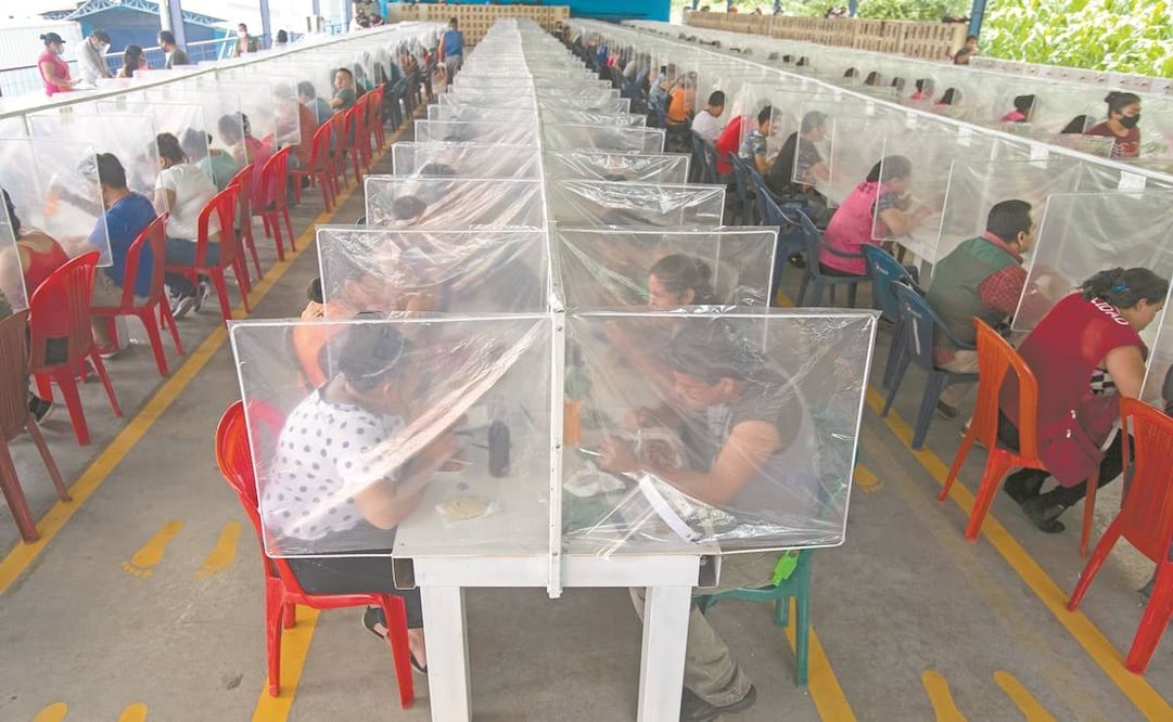 Los trabajadores almuerzan separados por paneles de plástico como medida contra el coronavirus en la firma K.P. Textil en San Miguel Petapa, Guatemala, el pasado 10 de julio. Foto: MOISES CASTILLO. AP