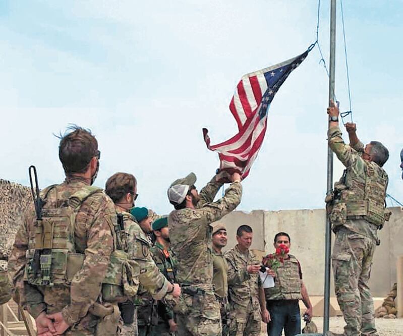 Soldados bajan la bandera de EU, durante una ceremonia de traspaso en Helmand. Foto: AFP