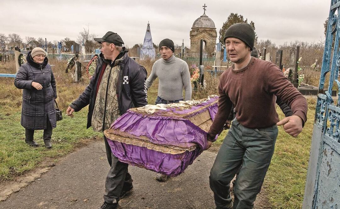 Los residentes llevan los restos exhumados de una niña de 15 años presuntamente asesinada durante la ocupación rusa en Pravdyne, a las afueras de Khersón. Foto: Roman Pilipey/EFE 