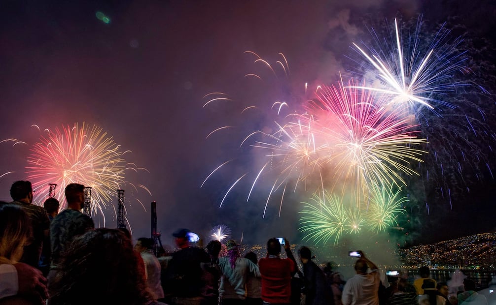 La gente mira los fuegos artificiales en el puerto de Valparaíso en la costa de Chile durante el Año Nuevo. Foto: AFP