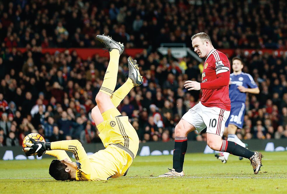 Thibaut Courtois, portero del Chelsea, le gana el balón a Wayne Rooney, goleador del Manchester United (JON SUPER. AP)