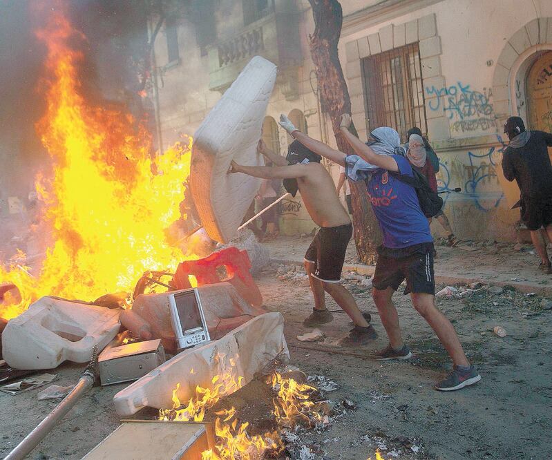 Defensa. Manifestantes queman un colchón para construir una barricada durante las protestas contra el gobierno, ayer en Santiago. CLAUDIO REYES. AFP