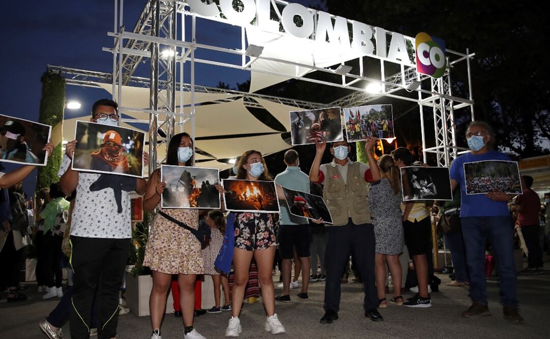 Manifestantes esperaban, a las afueras de la Feria del Libro de Madrid, al presidente colombiano con fotografías de la represión que hubo en las manifestaciones de abril. Foto: EFE