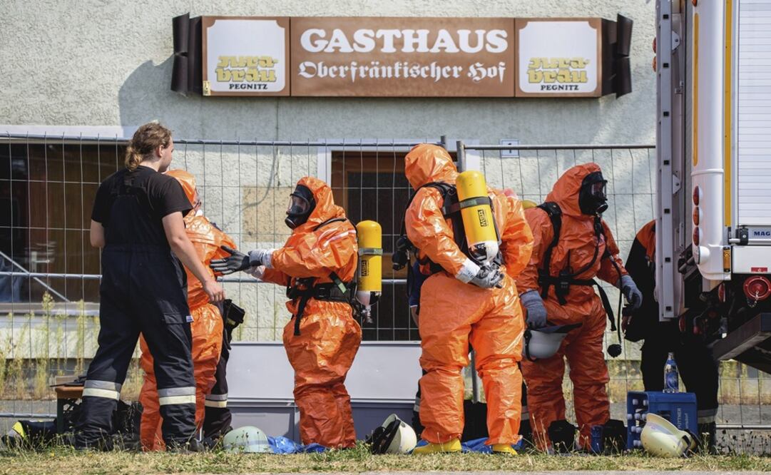Bomberos se visten con trajes protectores cerca del lugar donde el avión se estrello. (Foto: EFE)