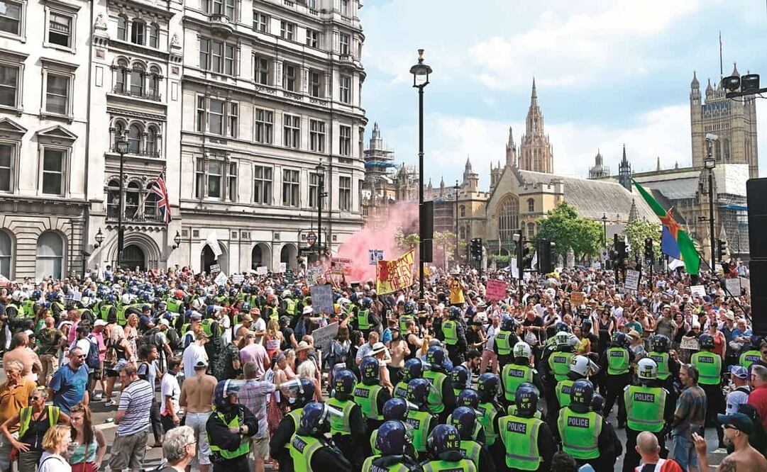 La policía inglesa bloquea a manifestantes durante una protesta contra el aislamiento en la pandemia. Este lunes el gobierno anunció el fin de las restricciones. Foto: Facundo Arrizabalaga. EFE